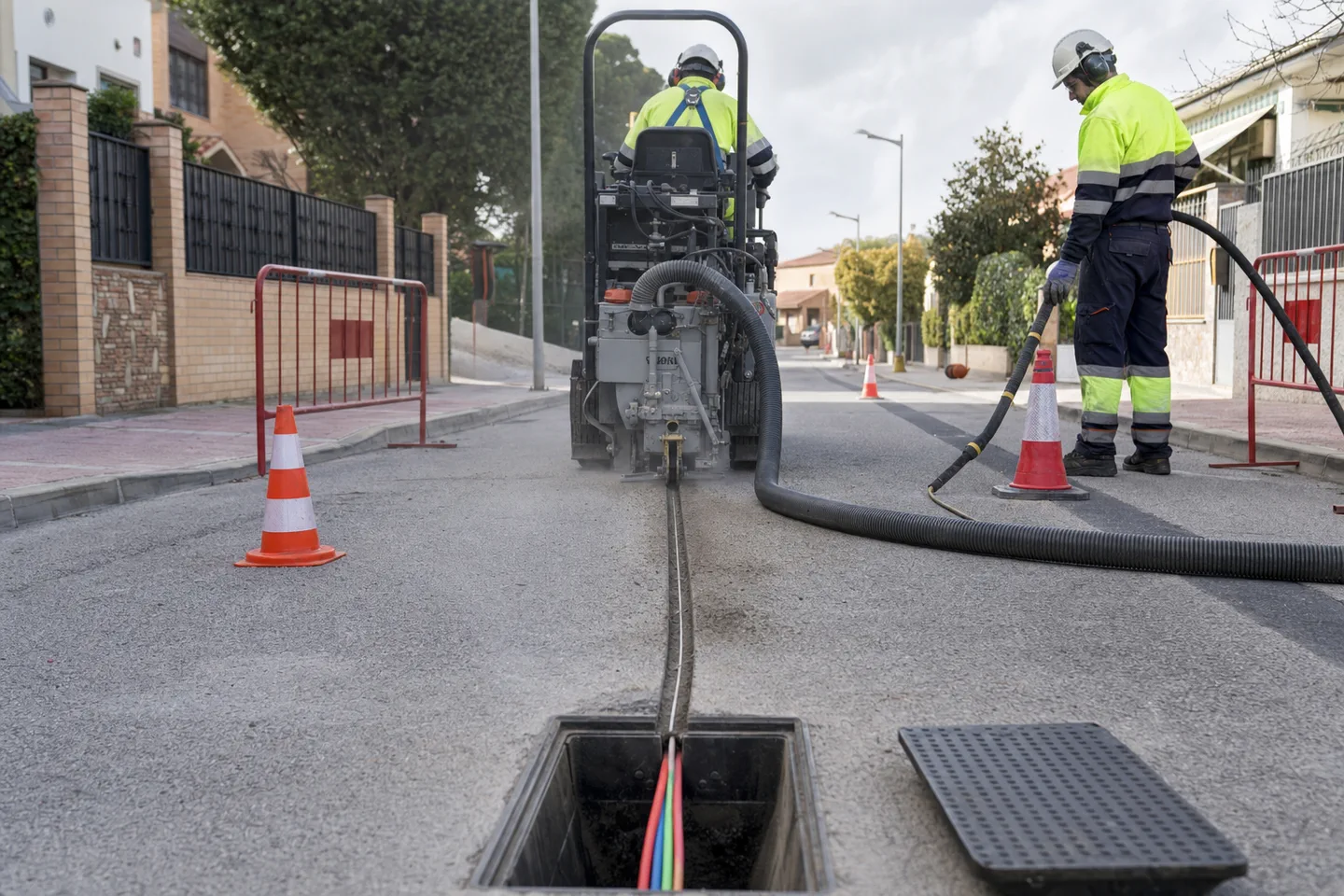 Microzanja urbana con conducto multitubular para fibra optica junto a arqueta de registro